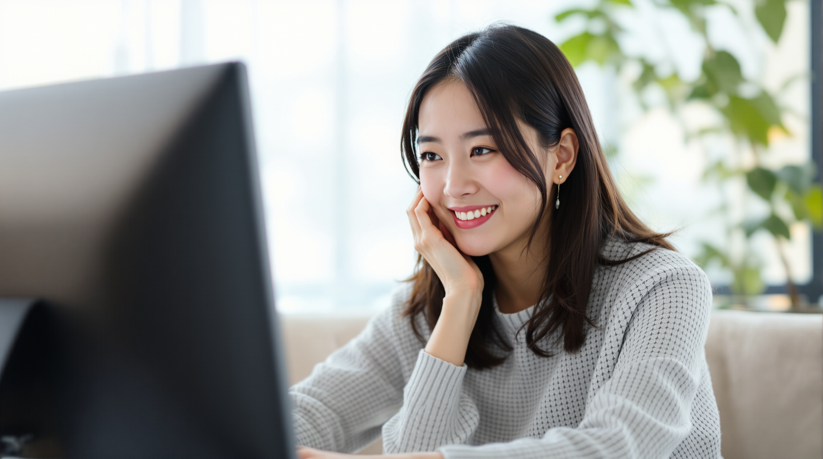 自然な笑顔でパソコンを見る女性