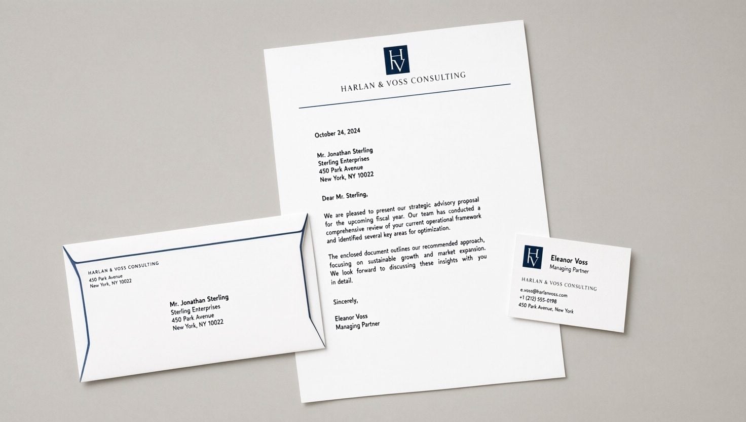 Flat lay of a matching brand suite: letterhead, business card, and envelope sharing one design system